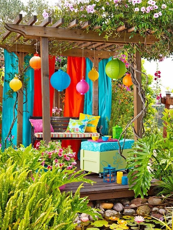 colorida decoración de jardín con pérgola, lámparas de colores y bancos con cojines