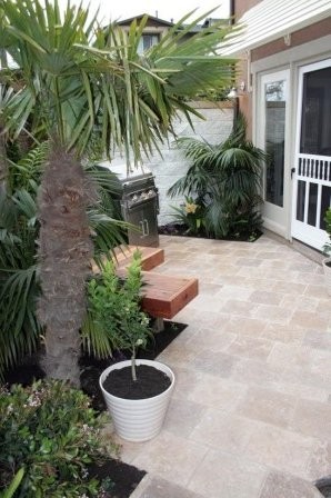 Terraza con grandes parterres y suelo de baldosas beige.