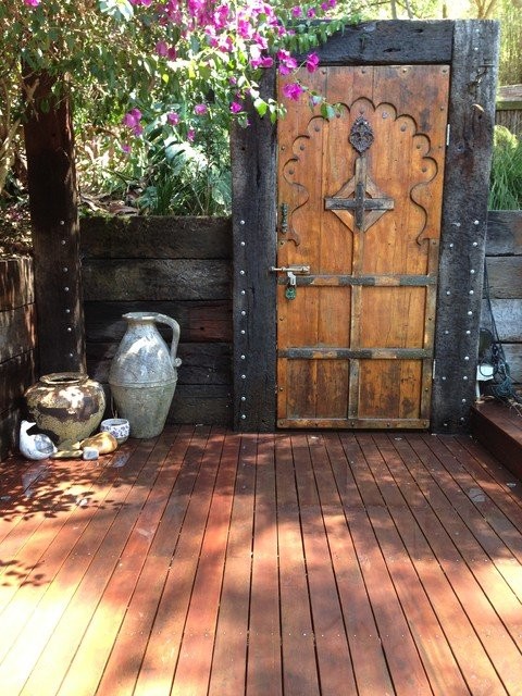 Terraza con suelos de madera y puerta rústica.